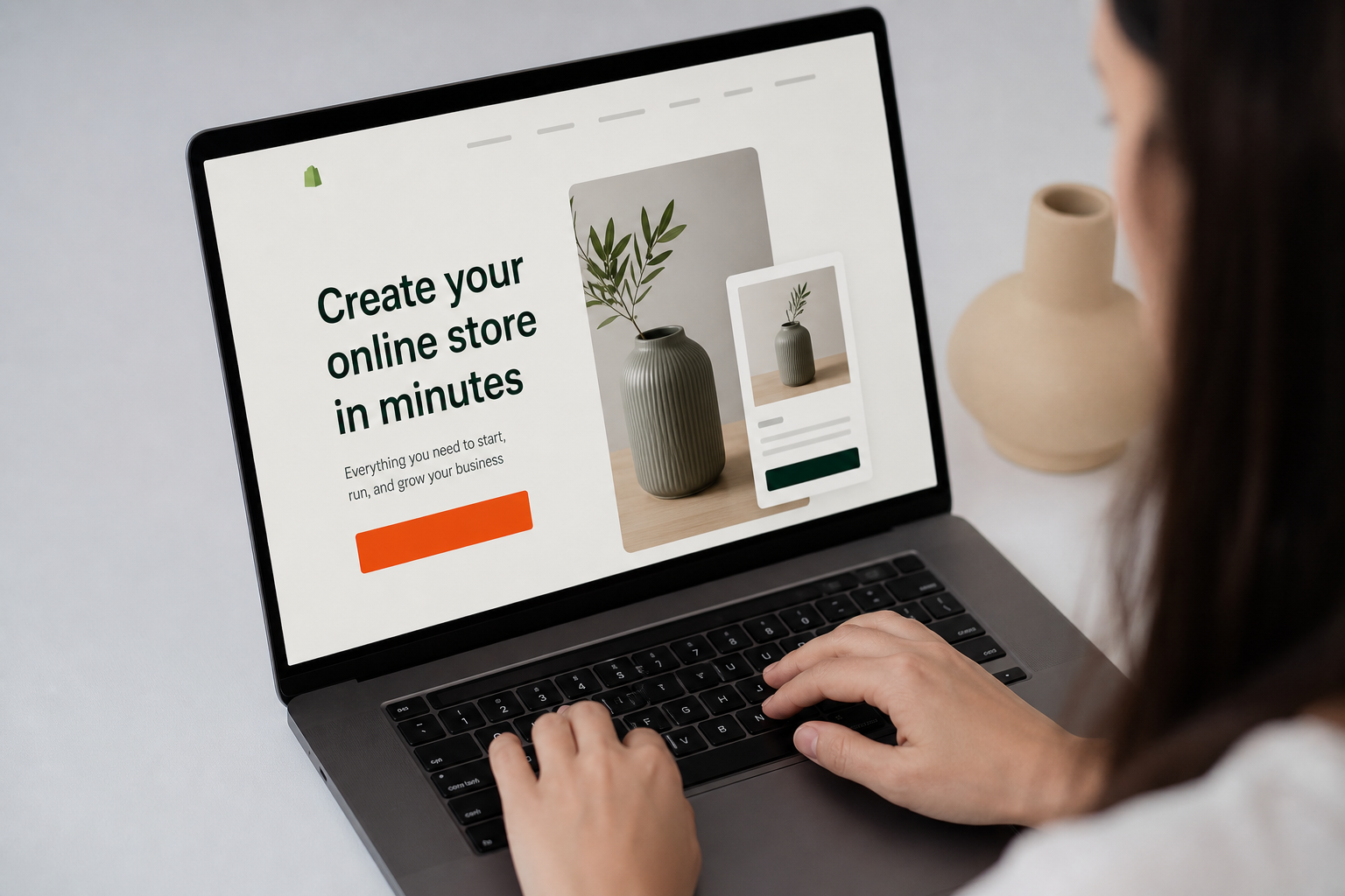 Close-up of a Shopify landing page on a laptop screen showing a bold headline, product image, and bright orange CTA button under cool office lighting